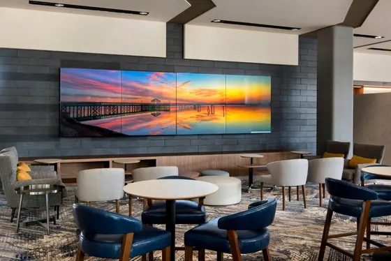 Lobby with tables and chairs and a large screen tv