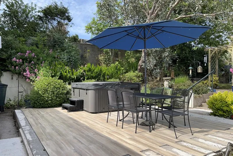 1 Gloucester Way garden-deck hot tub beside the blue parasol