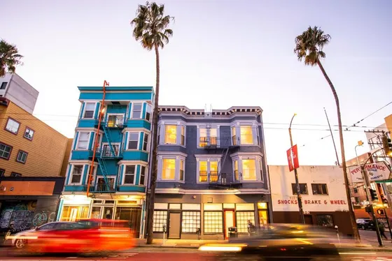 Building on the corner of a street with palm trees