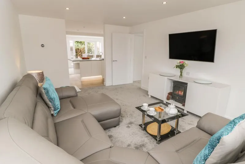 Abbey View living room with leather sofas and log burner