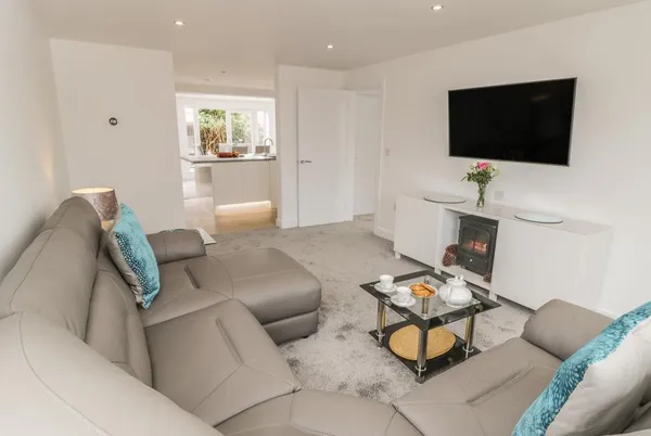 Abbey View living room with leather sofas and log burner