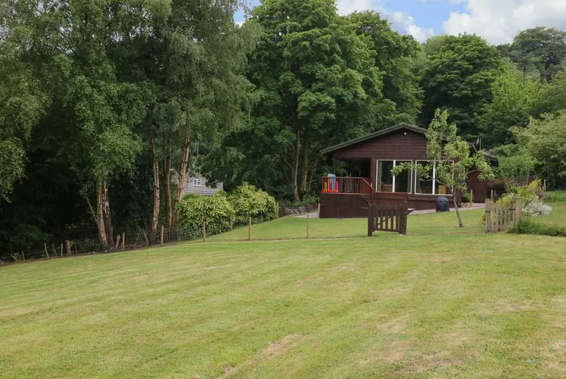 Kipling Lodge surrounded by mature trees and green lawn