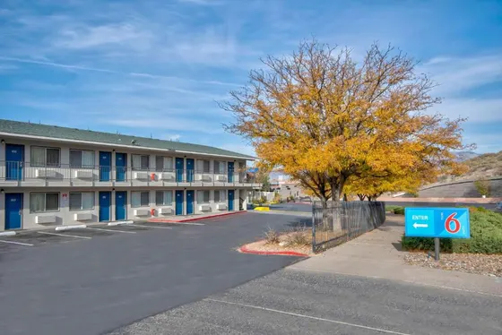Two-story motel with blue doors and a Motel 6 enter sign