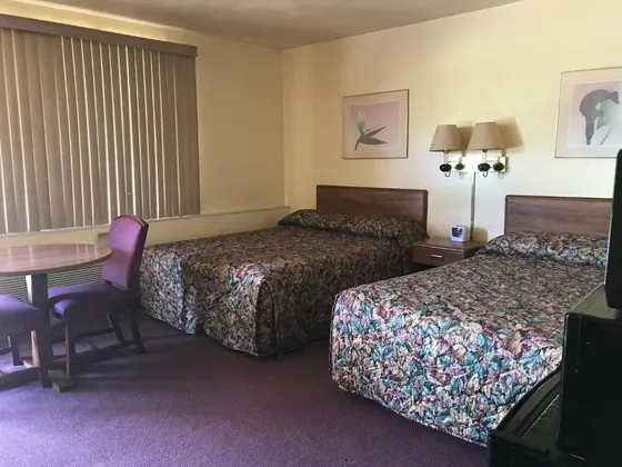 Hotel room with two beds and a table and chairs
