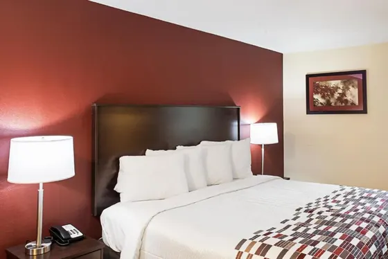 Bed with a terracotta wall and a patterned runner