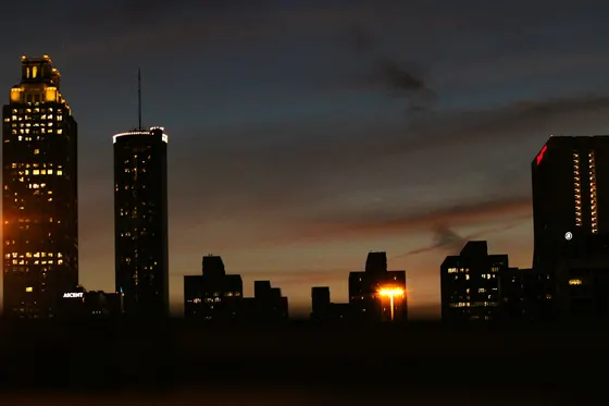 Atlanta skyscrapers silhouetted against a dark sunset sky