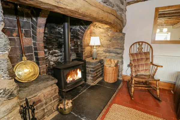 Maes Madog stone fireplace with lit stove