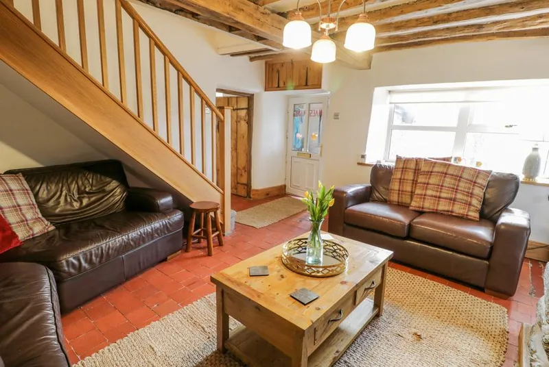 Maes Madog lounge with beams leather sofas and rustic fireplace