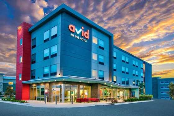 Blue avid hotel at sunset with a glowing glass lobby