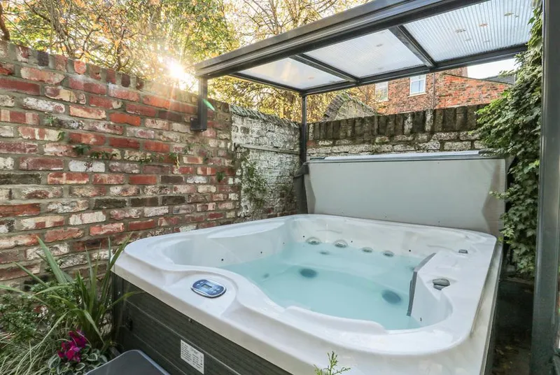 Baggergate House hot tub filled with water under glass canopy