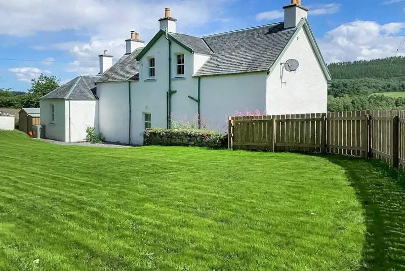 Balmore Farmhouse exterior with lawn and rural hills