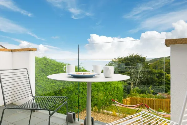 Bayside balcony breakfast table with sea view beyond the garden