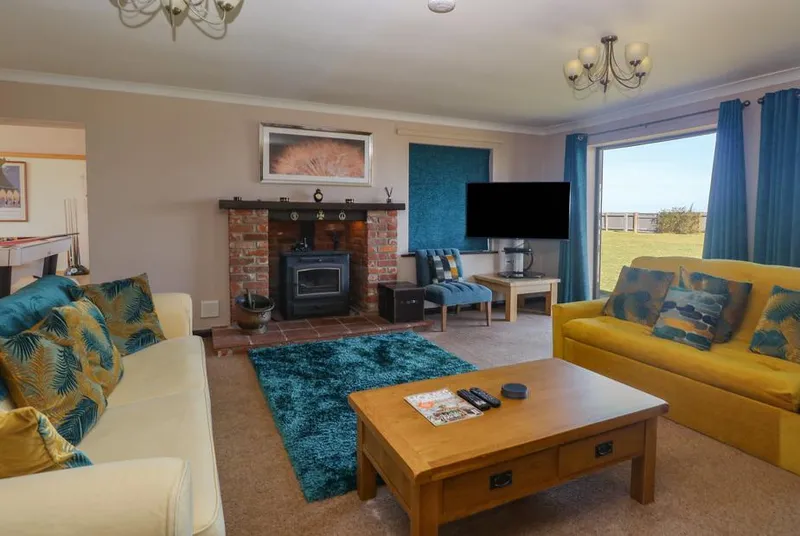 Beach Haven living room with wood burner and teal accent wall