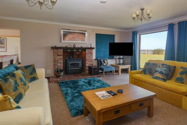 Beach Haven living room with wood burner and teal accent wall