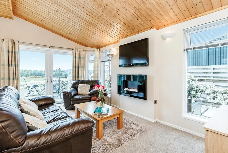 Beauly Lodge lounge with large windows and fireplace