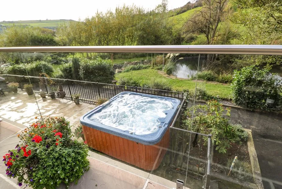 Belvedere Farm bubbling hot tub in garden with green hillside