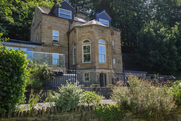 Belvedere Farm stone facade with turret bay window and woodland