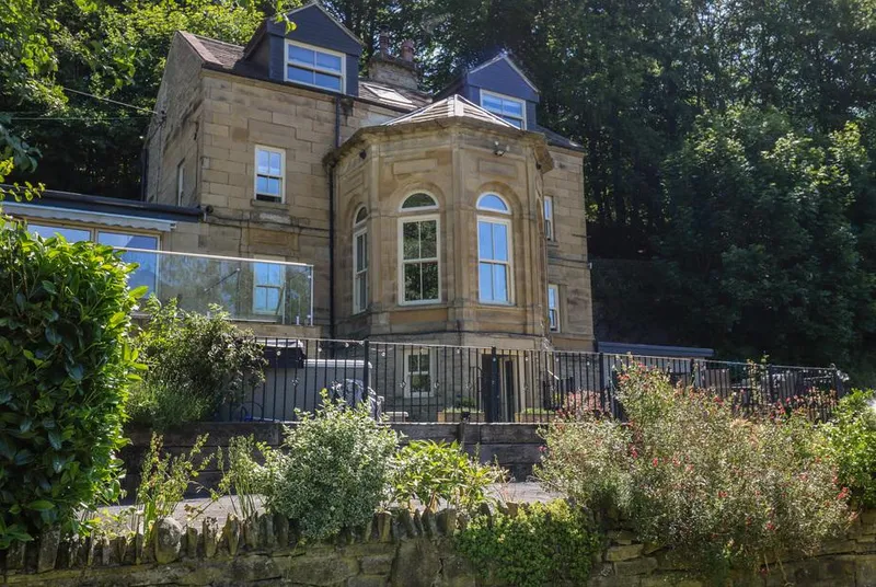 Belvedere Farm stone facade with turret bay window and woodland