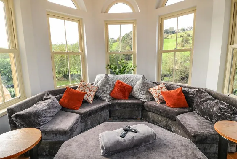 Belvedere Farm turret sitting room with panoramic windows and curved sofa