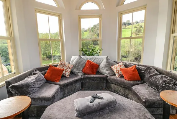 Belvedere Farm turret sitting room with panoramic windows and curved sofa