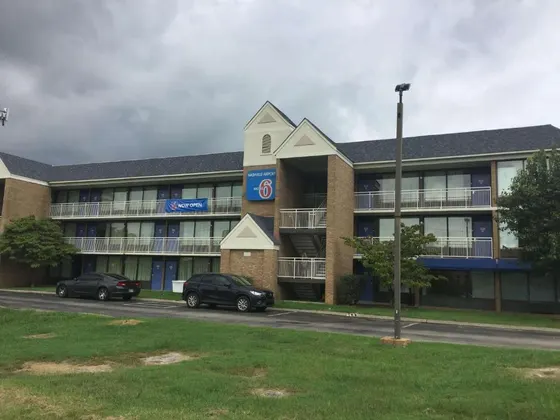 Building with two cars parked in front of it