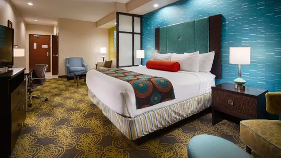 Teal-wall room with an orange bolster and yellow carpet