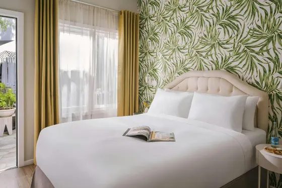 Bedroom with a white bed with a book on it