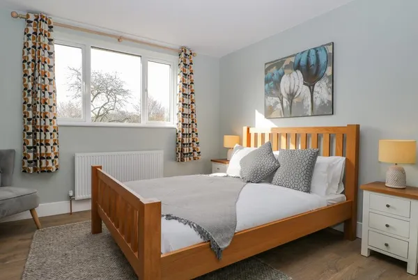 Birch House master bedroom with natural light and colourful curtains