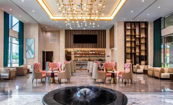 Lobby with pink chairs, marble floors, and a fountain