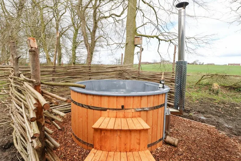 Bracken Fern wood-fired hot tub beside woodland and open fields