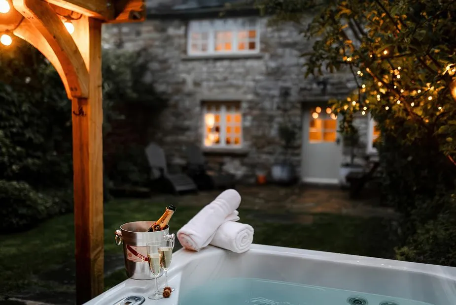 Bridge End Cottage evening hot tub with champagne and cottage behind