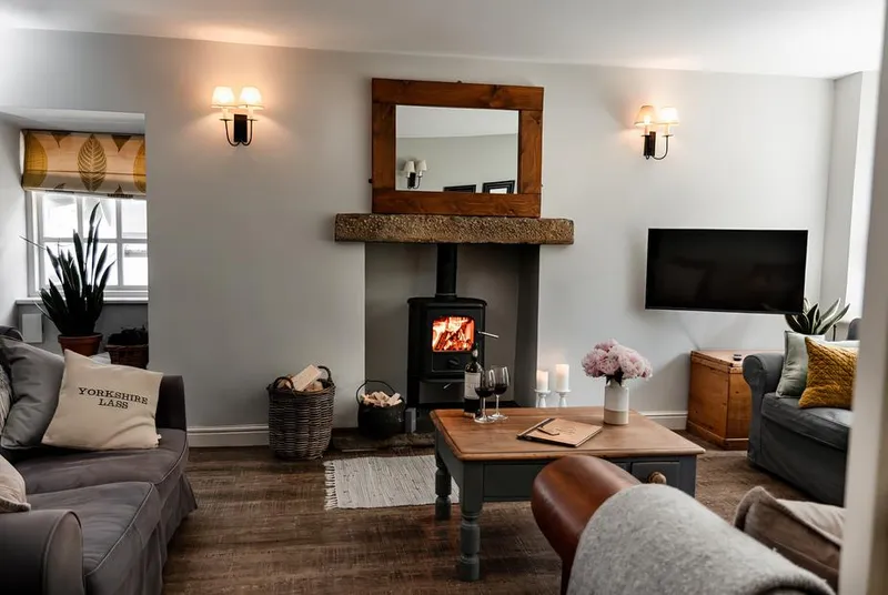 Bridge End Cottage living room with lit wood burner and wooden mantel
