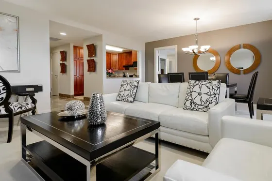 White sofa living room opening to a dining table