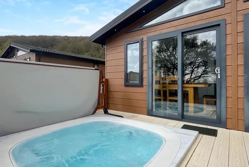 Brunel Premier Elegance Lodge 3 hot tub with blue water on deck with wooded hills