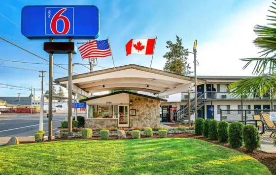 Gas station with two canadian flags on top of it
