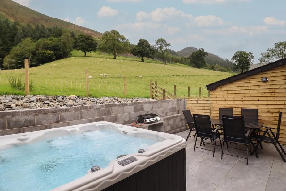 Bwthyn Camlan hot tub patio with mountain meadow backdrop