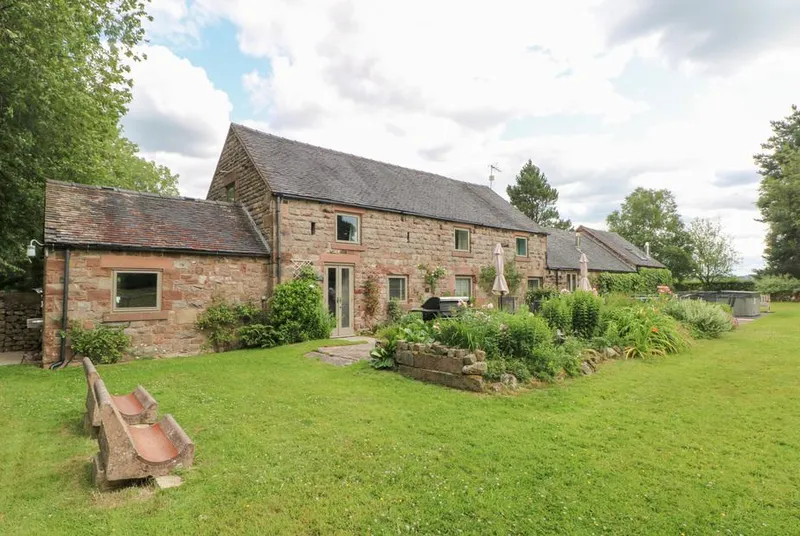 Lee House Cottage front-angle stone facade with garden bench