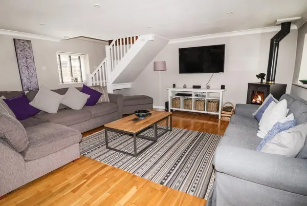 Lee House Cottage living room with lit wood burner and two sofas