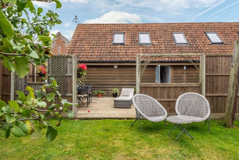 Cartshed Lodge Hoveton timber barn conversion with tiled roof and pergola