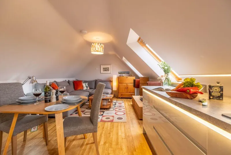Cartshed Lodge Hoveton open-plan loft with dining table and corner sofa