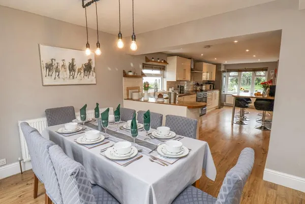 Castle View dining room set for eight flowing into open-plan kitchen