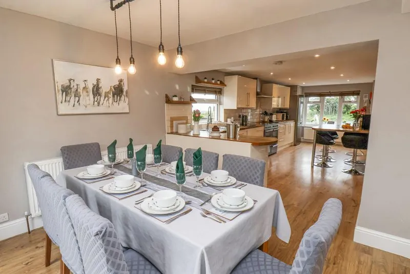 Castle View dining room set for eight flowing into open-plan kitchen