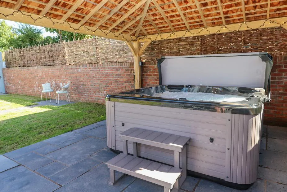 Catamouse hot tub under oak gazebo in a private courtyard