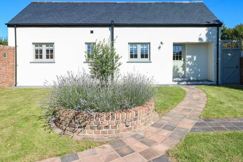 Catamouse white cottage exterior with curved path and lavender bed