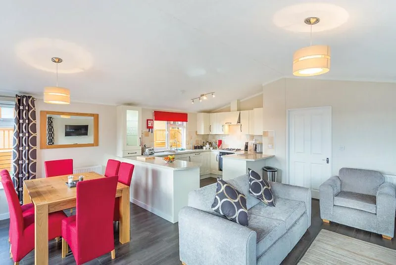 Cheddar Lodge Premier WF open-plan living and dining with red chairs and grey sofas