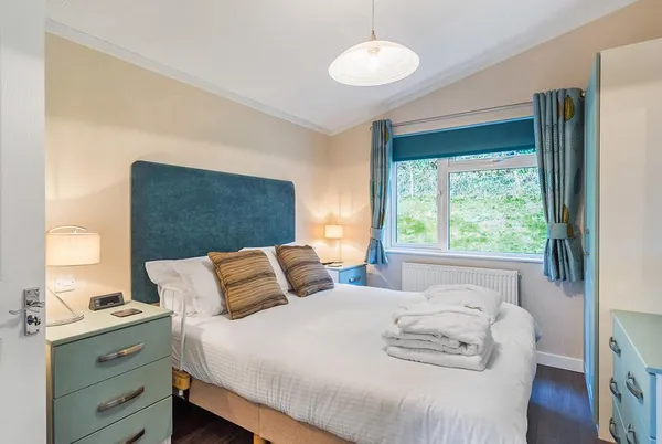 Cheddar Lodge Premier WF master bedroom with teal headboard and warm lighting