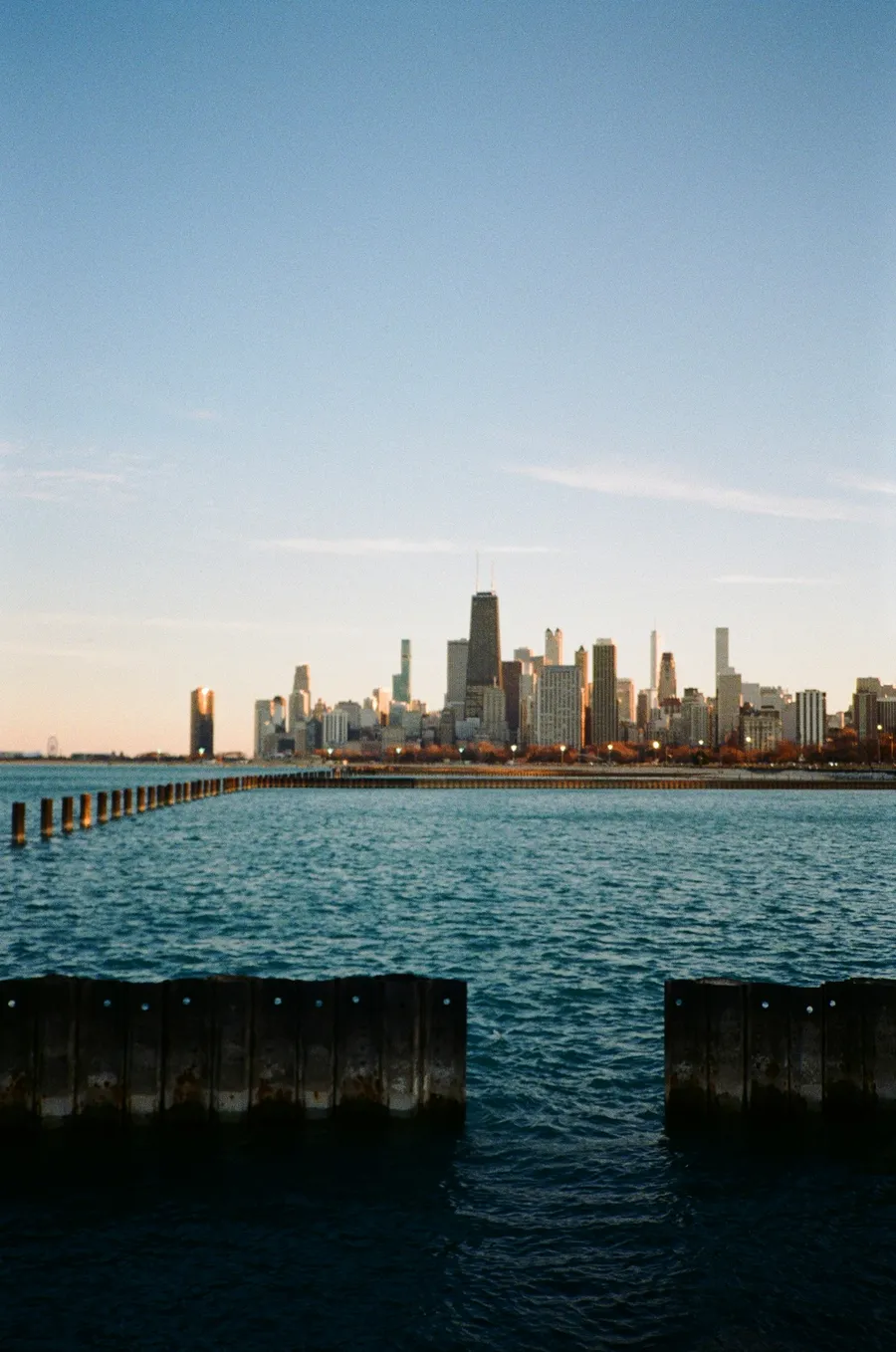 City skyline across blue water at golden hour