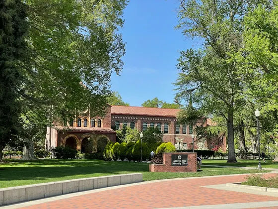 Brick California State University, Chico building behind a green lawn