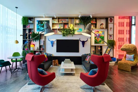 Lounge with red wingback chairs and a colorful bookshelf