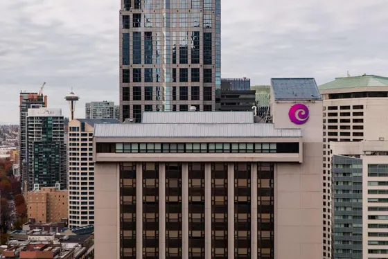 Building with a logo on top of it in a city